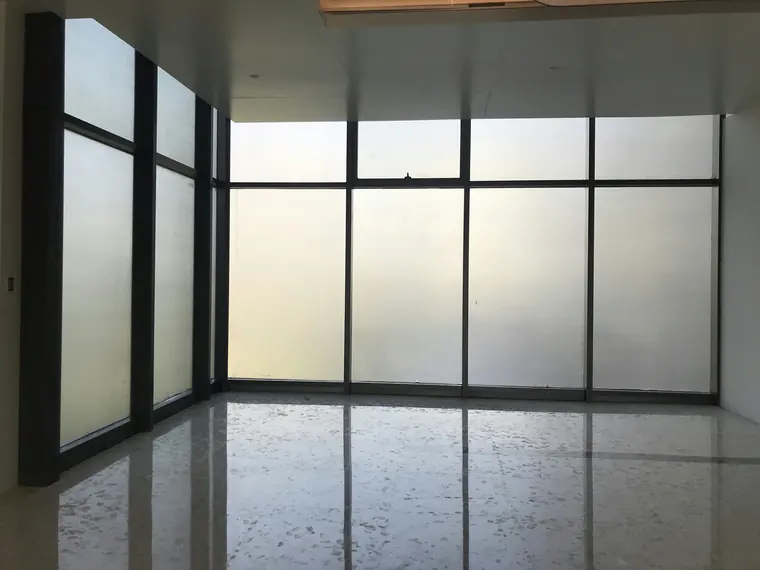 Paroi vitrée toute hauteur en verre dépoli dans une pièce vide