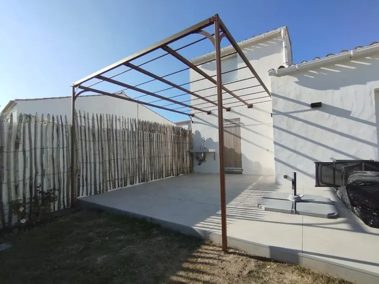 Charpente métallique de pergola sur une terrasse en béton