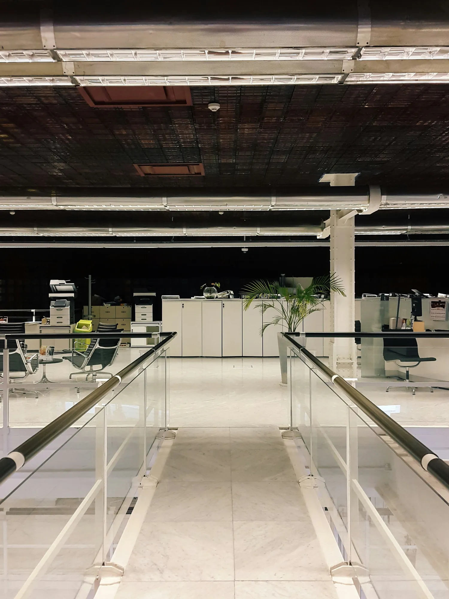Garde-corps vitré à main courante inox sur un plateau de bureaux