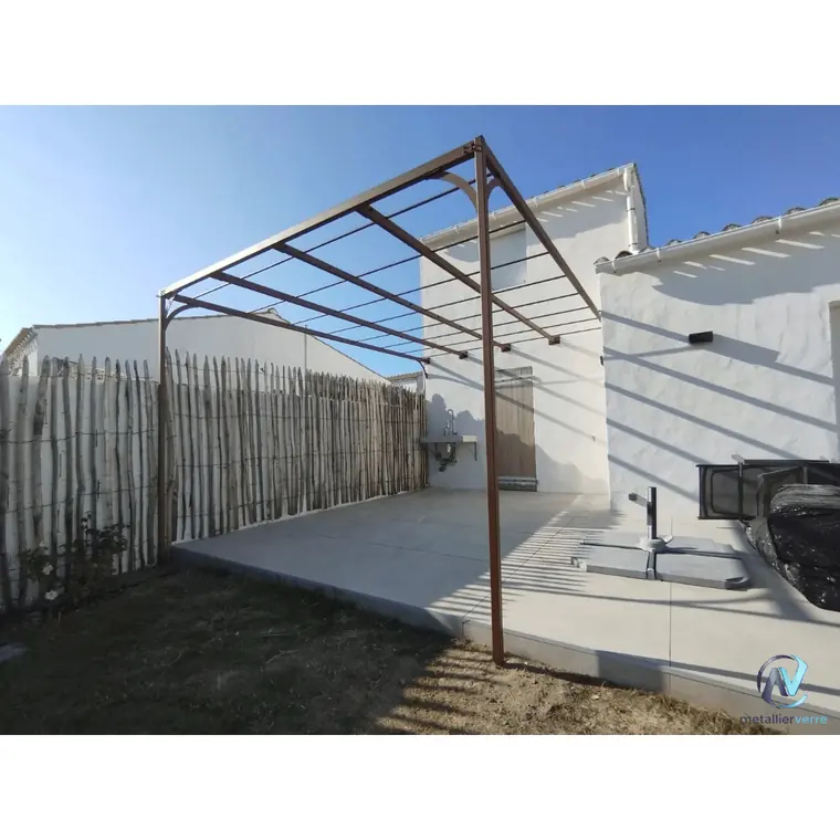 Ossature de pergola en acier brut adossée à une façade blanche