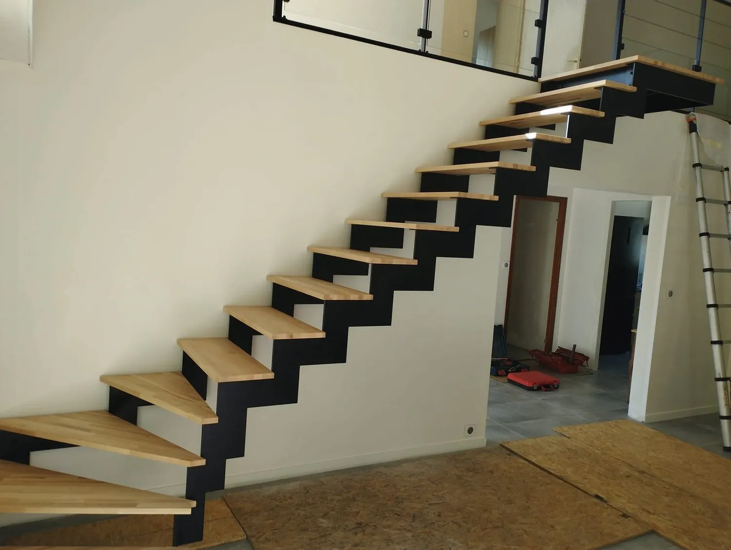 Escalier à crémaillère acier noir et marches bois, chantier en cours
