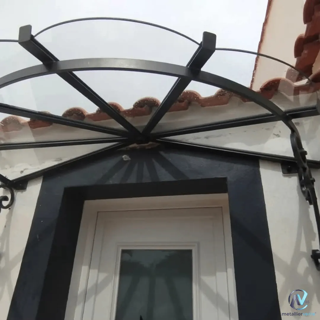 Marquise cintrée en fer forgé au-dessus d'une porte d'entrée