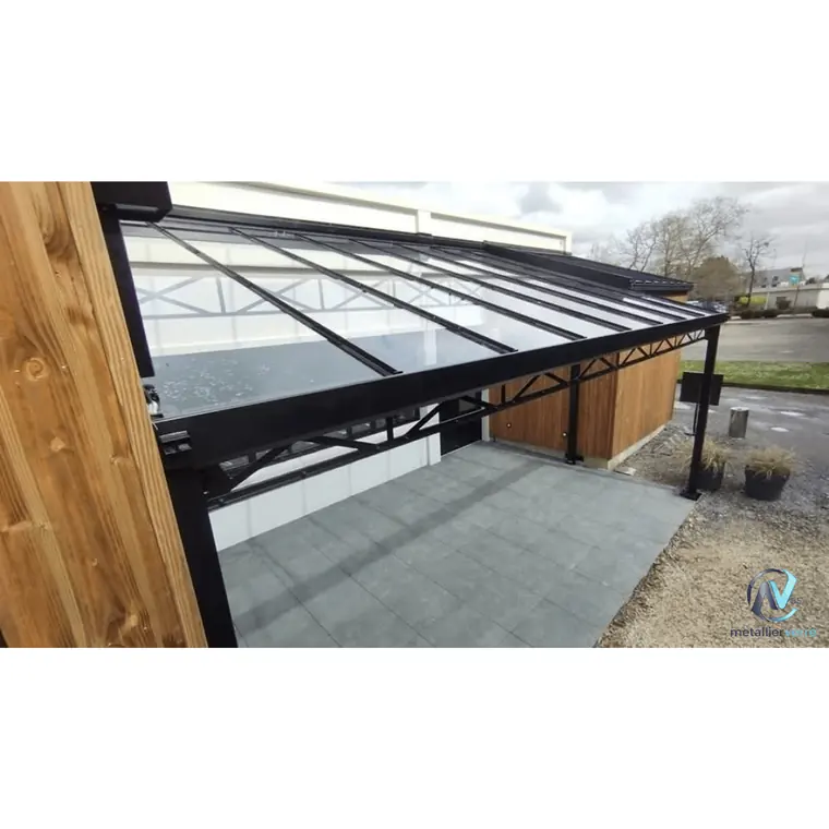 Auvent vitré en acier noir sur une terrasse dallée