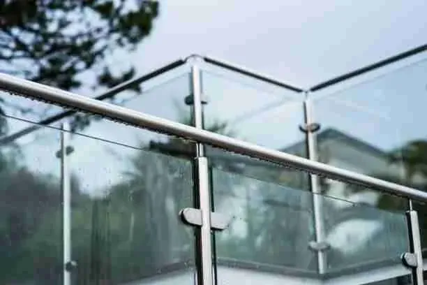 Angle d'un garde-corps vitré fixé par pinces inox