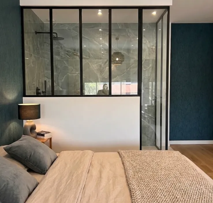 Verrière en acier noir entre une chambre et une salle d'eau
