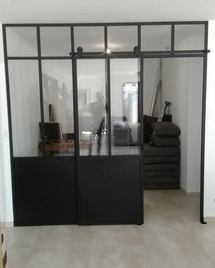 Verrière noire à porte coulissante et allège pleine dans un séjour